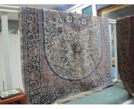 A RUG the white indigo and light pink ground with oval foliate panel within a conforming border 190cm x 115cm