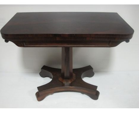 A REGENCY ROSEWOOD FOLD OVER CARD TABLE on octagonal pillar and platform base 92cm wide