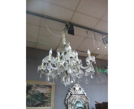 A CONTINENTAL TWELVE LIGHT CHANDELIER hung with pendant drops