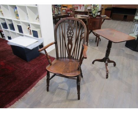 Circa 1860 an elm and ash hoop back Windsor elbow chair with stick back rest having a wheel central splat on ring turned legs