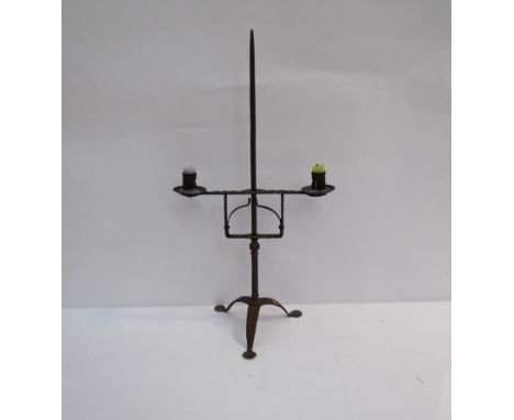 A 18th Century wrought iron twin candle stand on a tripod spade foot base, 57.5cm tall