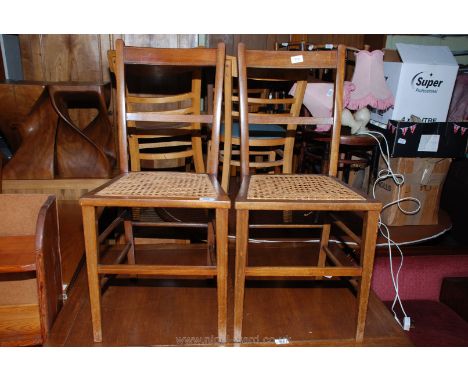 A pair of cane seated ladder back chairs.