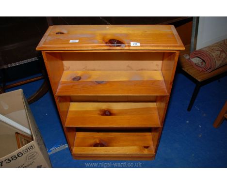 A three shelf honey Pine bookcase, 25" x 9" x 36" high.