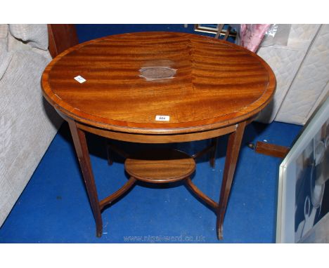 An Edwardian oval Mahogany occasional table with cross-banding, the slender legs united by an under-shelf, (central inlay to 