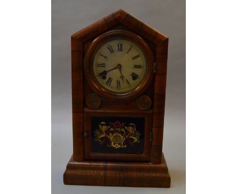 An American Eight Day movement chiming mantle clock with tin face and coat of arms panel to frontage, with pendulum. [COLLECT