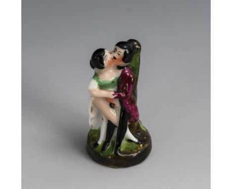 Erotische Miniaturfigur. Ungemarkt, um 1850.             Polychrom bemalt, goldstaffiert. H 4 cm.             Am einem Baumst