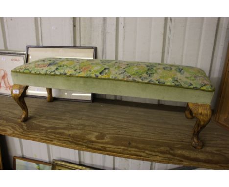 A needlework upholstered oblong stool raised on cabriole supports