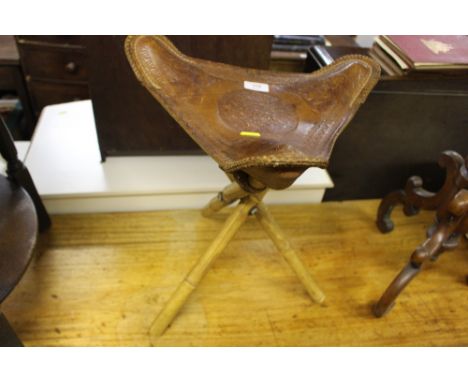 An unusual  Eastern leather top folding stool embossed with figures