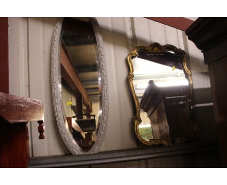A gilt framed mirror and an oval mirror