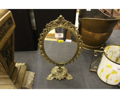 An oval brass dressing table mirror