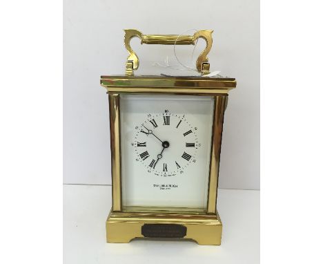 A large brass and glass cased English carriage clock, manufactured by Taylor & Bligh, with presentation plaque to front (with
