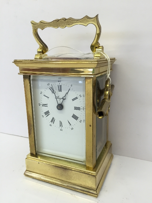 A French brass and glass cased carriage clock, manufactured by Angelus.