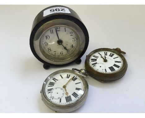 A small ebony cased circular mantle clock resting on two ball feet together with two silver plated pocket watches.
