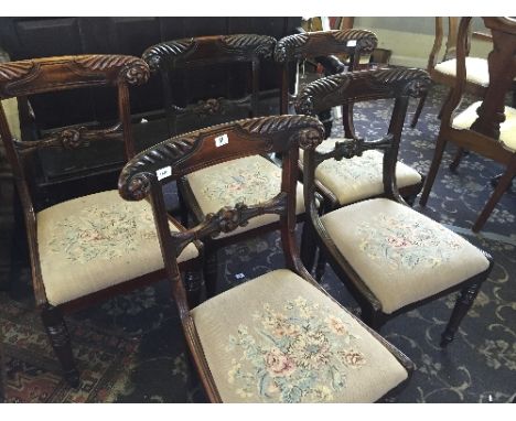 A set of five early 19th century mahogany framed dining chairs with tapestry covered lift-out seats.