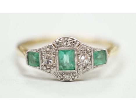 A 1920's 18ct &amp; plat, millegrain set three stone emerald and four stone diamond ring, size R/S, gross weight 2.5 grams.