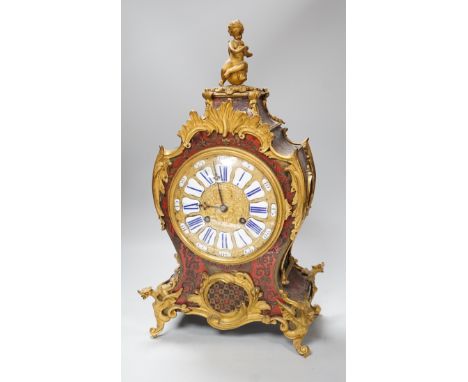 A French scarlet Boulle work and ormolu mounted mantel clock with enamel dial, 45cms high