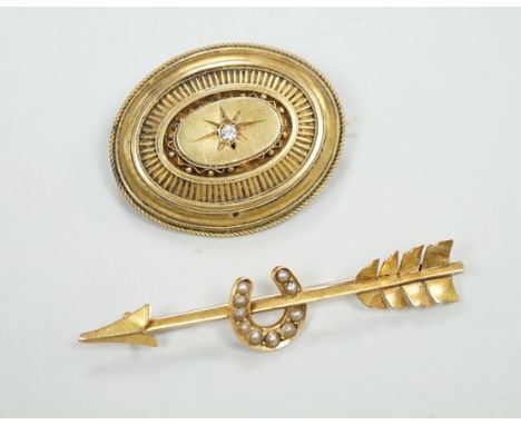 An early 20th century yellow metal, and seed pearl set arrow and horse shoe brooch, 60mm and a Victorian paste set yellow met