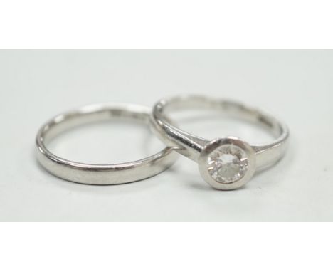 A modern platinum and collet set solitaire diamond ring, size M, gross weight 4.9 grams, together with a modern platinum wedd