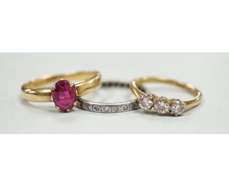 An 18ct and solitaire synthetic? ruby set ring, an 18ct and three stone diamond ring and a white metal and diamond chip set f