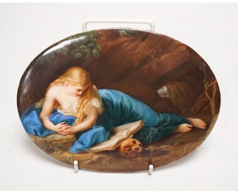 A 19th century painted porcelain oval plaque of a reclining lady reading a book. The reverse stamped L. Sturm Dresden. 15x19.