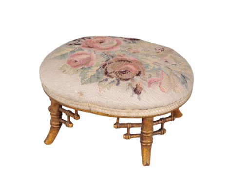 A VICTORIAN GILTWOOD OVAL FOOTSTOOL 19th Century, with bamboo style legs, the top upholstery in floral tapestry, 16cm high x 