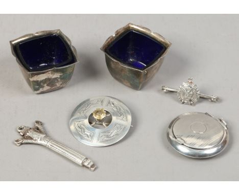 A group of silver items to include Scottish brooch, pair of salt cellars, compact etc.