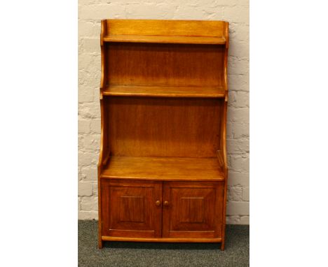 A light oak waterfall bookcase over cupboard base.