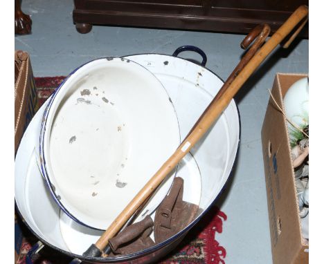 A white enamel twin handle babies bath, along with two cast irons and two walking sticks.