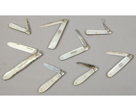 Seven mother of pearl handled pocket knives all with silver blades, along with a mother of pearl and silver button hook.