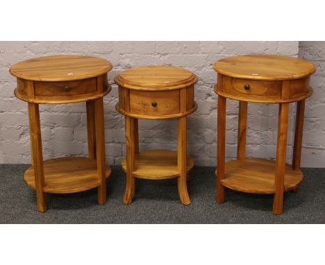 A pair of hardwood two tier lamp tables and a similar drum table.