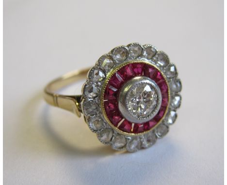 A Diamond and Ruby target Ring millegrain-set old-cut diamond within frame of tapered ruby baguettes and outer frame of rose-