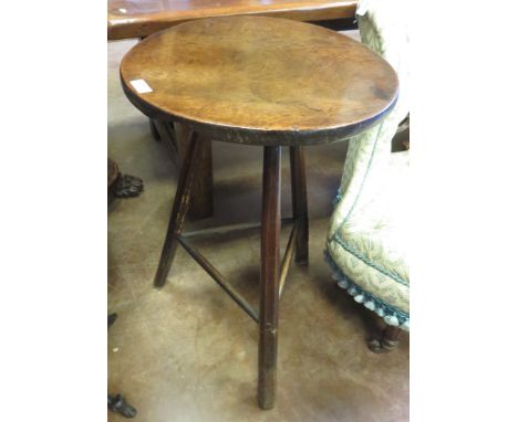 A George III oak Cricket Table, the single piece circular top raised on three stick legs with turned stretchers, 1ft 6in W