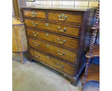 A Georgian oak Chest of two short and four long graduated drawers with mahogany cross-banding on bracket feet, 3ft 4in