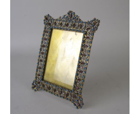 A brass Photograph Frame with intricate pierced border set red, white and turquoise coloured glass, and enamel A/F, 8in
