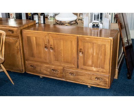 An Ercol Sideboard, Three Cupboards above two drawers, interior drawer for cutlery, raised on castors.  Height 30" widthe 51"