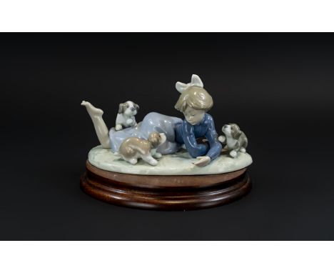 Lladro Hand Painted Porcelain Figure 'Little Girl Playing With Puppies', model no.5473, with display stand, 7 inches (17.5cms