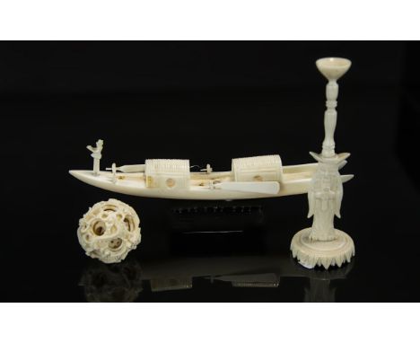 An Antique Chinese Carved Ivory Concentric Ball on Stand, overall height 7". With a Chinese ivory model of a boat, 7" long.