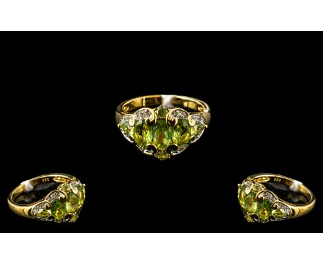 Peridot and Topaz Cluster Ring, five graduating, oval cut peridots, set across the finger, with a small, round cut above and 