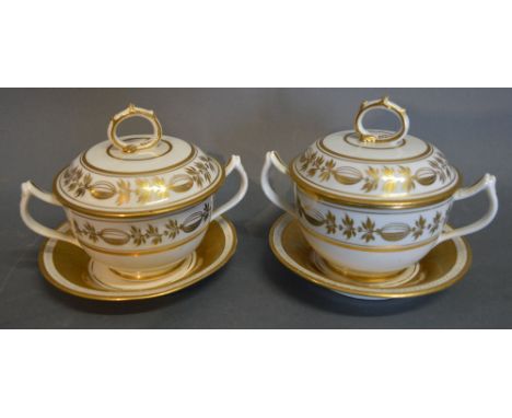 A Pair of Dagoty Paris Porcelain Covered Two Handled Cups and Saucers, highlighted in gilt upon a white ground