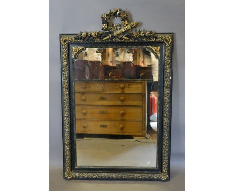 A 19th Century French Ebonised and Gilded Wall Mirror with Pierced Bow Cresting, 117 x 74 cms