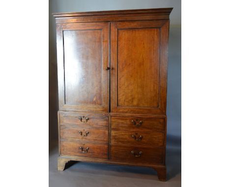 A 19th Century Mahogany Linen Press, the moulded cornice above two doors enclosing a hanging space above simulated drawers ra