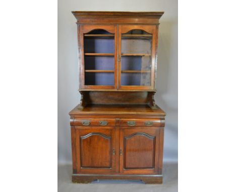 A Late Victorian Dresser, the moulded cornice above two doors enclosing shelves, the lower section with two drawers and two c