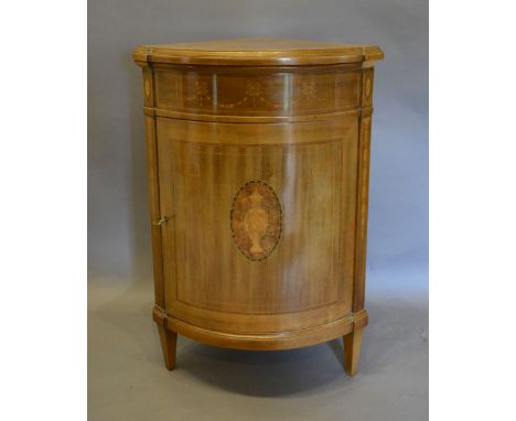 A 20th Century Mahogany Marquetry Inlaid Standing Corner Cabinet, the moulded top above a frieze inlaid with bows and swags, 