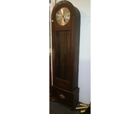 An Oak Longcase Clock, having an arched top enclosing a silvered dial with Arabic numerals and with a striking and chiming mo