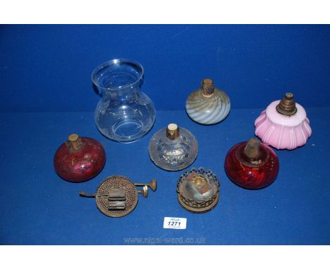 A quantity of oil lamp fittings including cranberry glass, milk and swirl glass  and cut glass reservoirs, etched shade, etc.