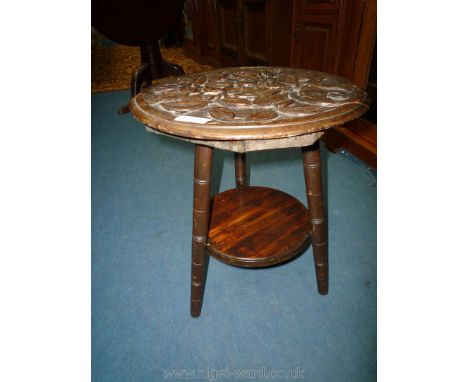 A pretty early 20th c. Mahogany arts and crafts circular Occasional Table, the top deeply carved with trailing fruiting branc