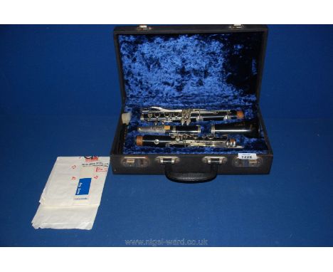 A cased Boosey &amp; Hawkes London Regent Clarinet, complete, case lined in blue together with a Guinness harmonica.