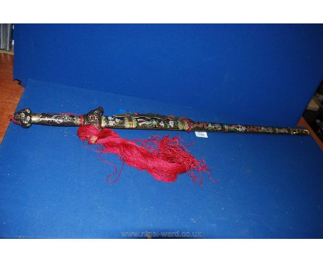 A reproduction Sword with decorative handle and scabbard with red tassels.  