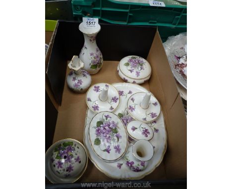 A china dressing table set, white ground decorated with violets including tray, two ring holders, small vase, lidded trinket 