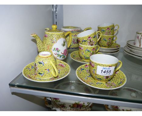 An oriental Teaset, yellow ground with ornate embossed scrolling and floral design, six cups and saucers and teapot with matc